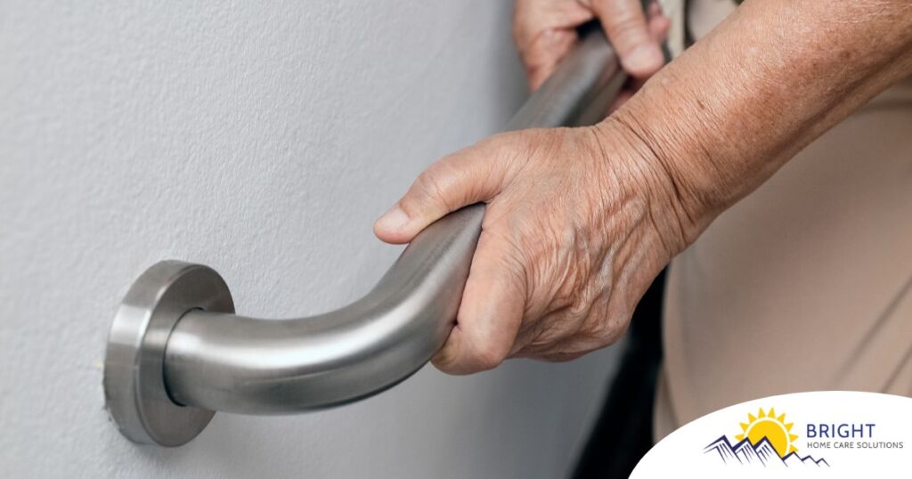 An older adult uses a grab bar representing one of the home modifications that is helpful for fall prevention for elderly adults.