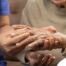 A care provider examines an older adult’s fingers, representing what would happen in an examination for rheumatoid arthritis.