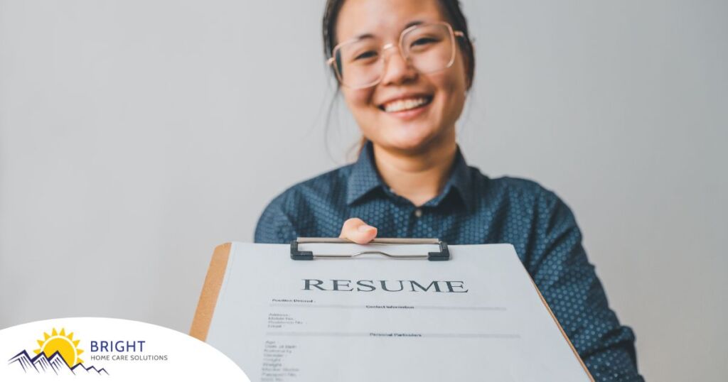 A woman happily hands in a resume, representing a successfully written caregiver resume.